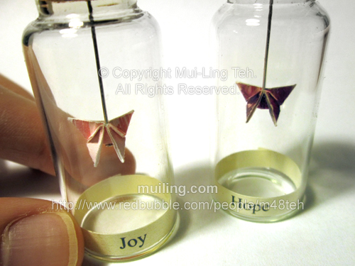 Colourful miniature origami butterflies in bottles by Mui-Ling Teh, with the label "Joy" and "Hope" below